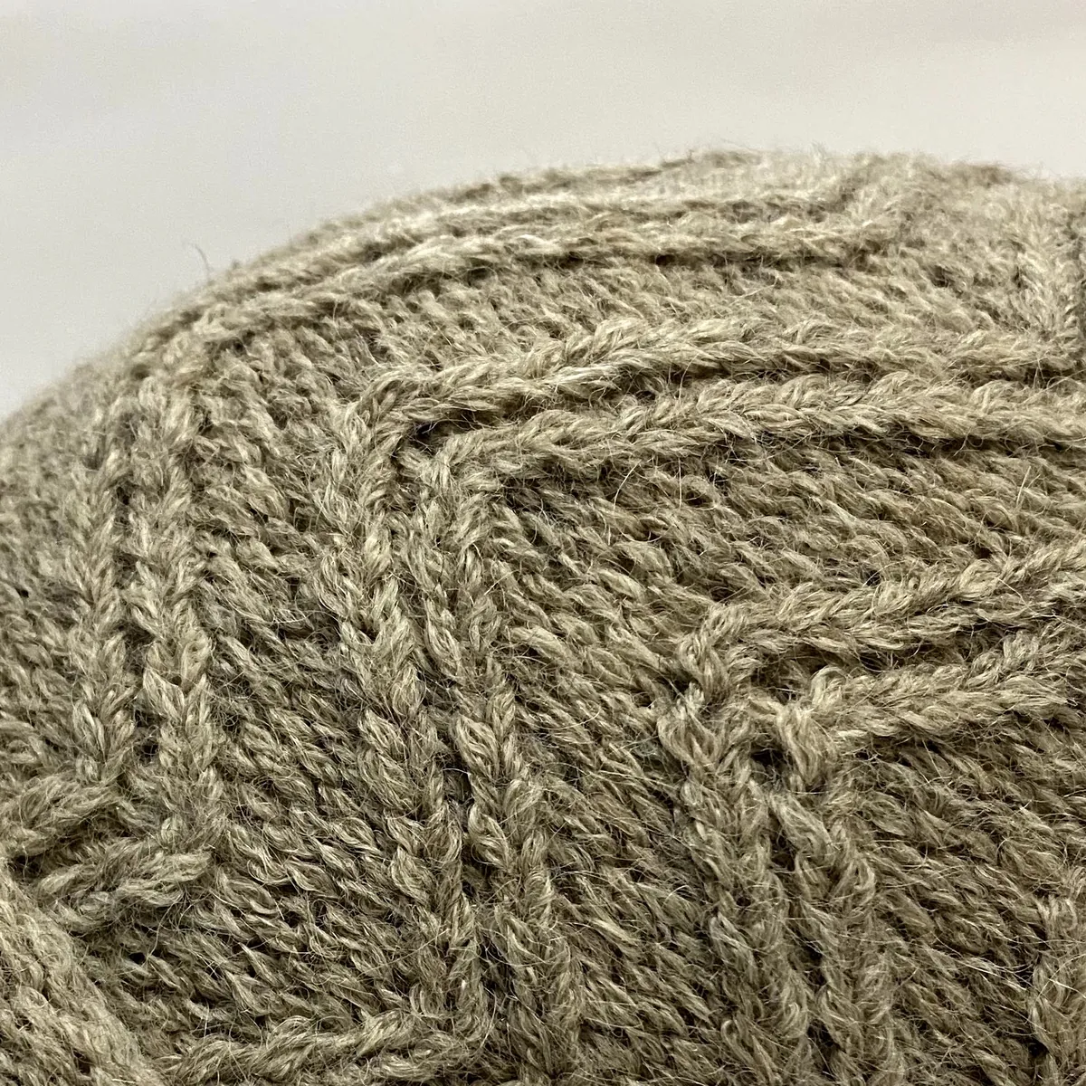 Detalle del punto en zigzag de un gorro tejido en alpaca beige natural.